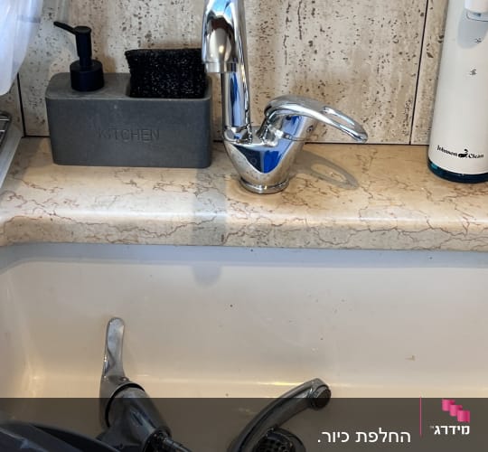 ברזים בכיור מטבח עם כלים לניקוי